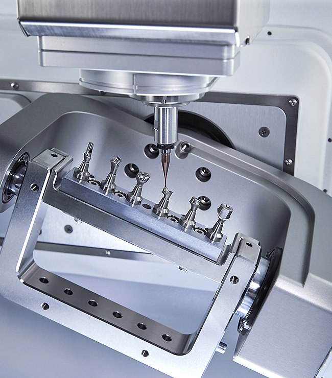 Premill titanium blanks held in the ARUM A5 Pro jig under the spindle