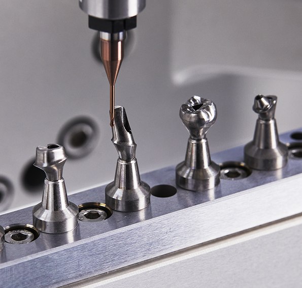 Premill titanium abutments being milled on the ARUM A7 jig