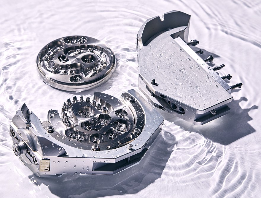 Milled metal frameworks still in their ARUM A7 jigs, photographed in water after wet milling